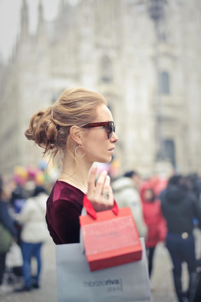 Chic woman with shopping bags in Piazza del Duomo, Milan, Italy.